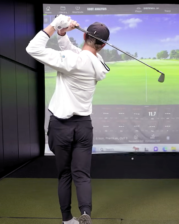 A young man hitting a golf ball in a fitting bay